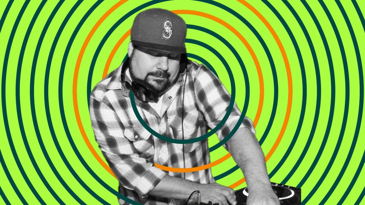 DJ Tamm t plays while holding headphones in place with shoulder