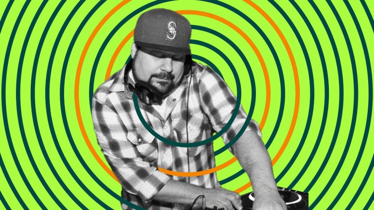 DJ Tamm t plays while holding headphones in place with shoulder