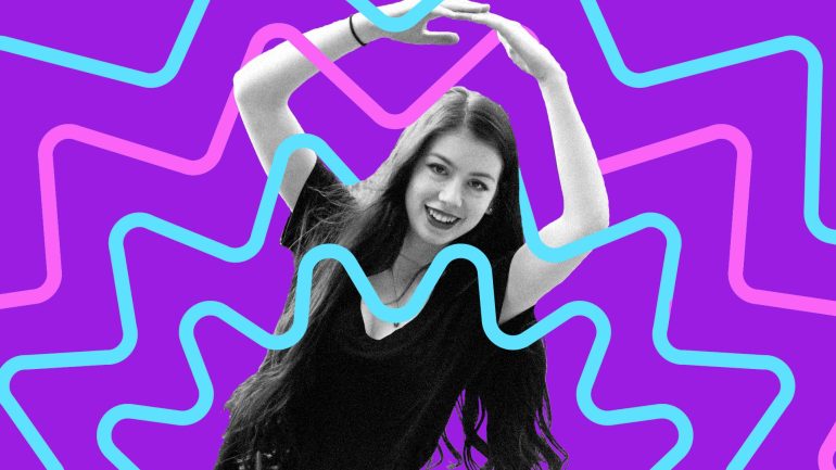 Dakota Fox smiles and holds arms above head in an oval shape