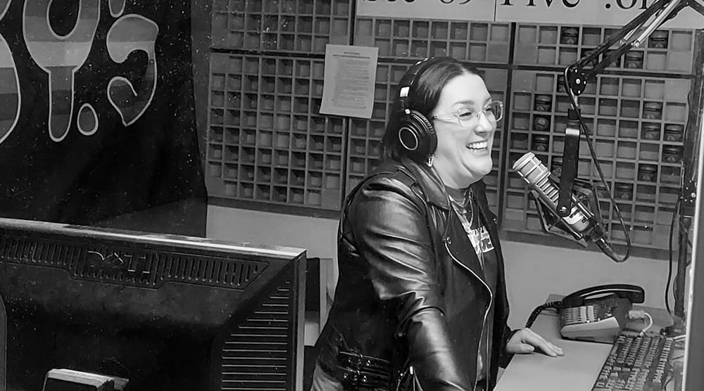 Harmony Soleil in a radio studio speaking on the mic while laughing