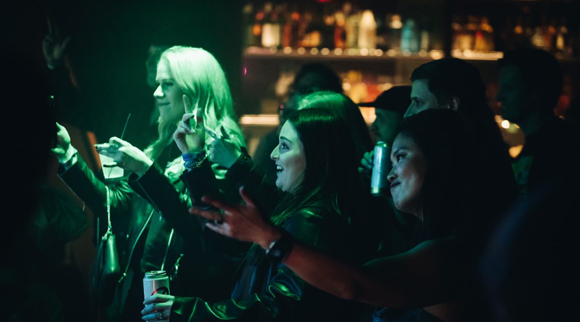 People in the crowd smiling on the dance floor