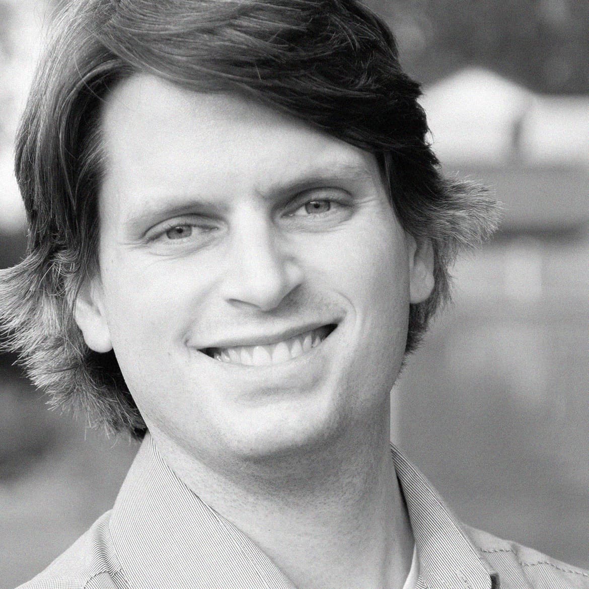 An image of a man smiling with a patterned background